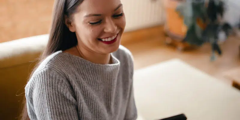 Jasmine smiling at her phone