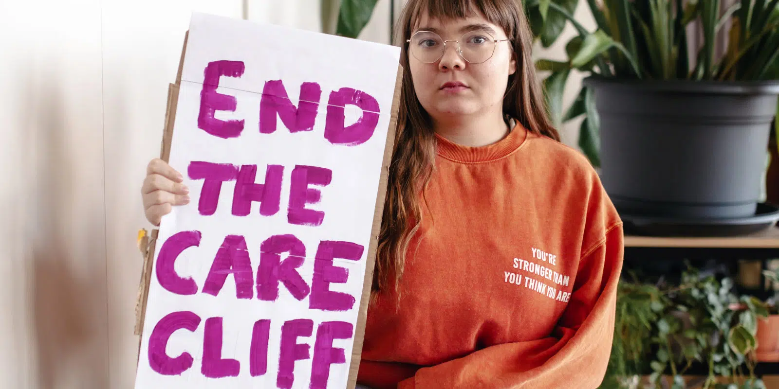 Zara holding end the care cliff sign sat down