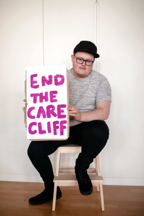 Ozzy sat with end the care cliff sign