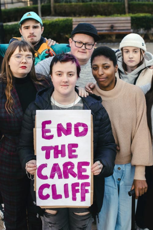 Group of young people staring into camera with end the care cliff sign