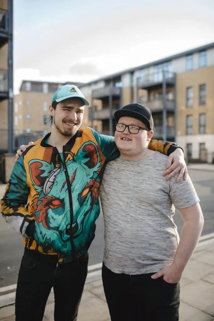 Ozzy and Aaron arms around each other stood outside
