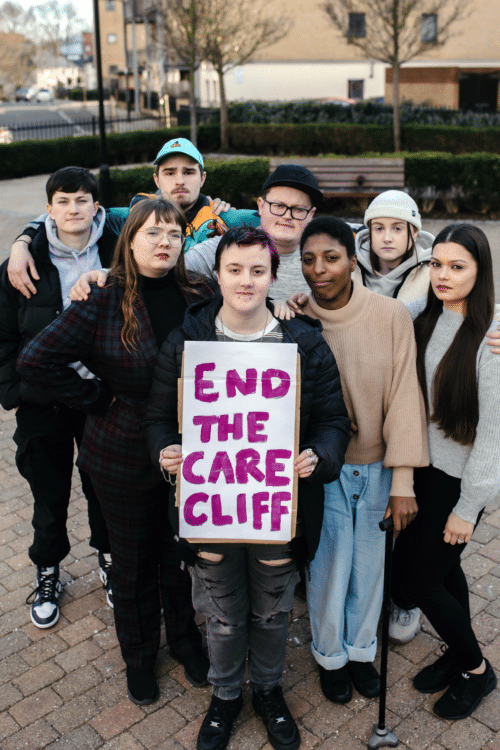 Group of young people holding sign saying end the care cliff