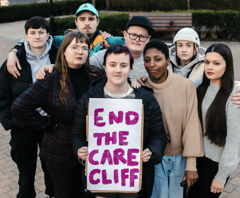 Group of young people holding sign saying end the care cliff