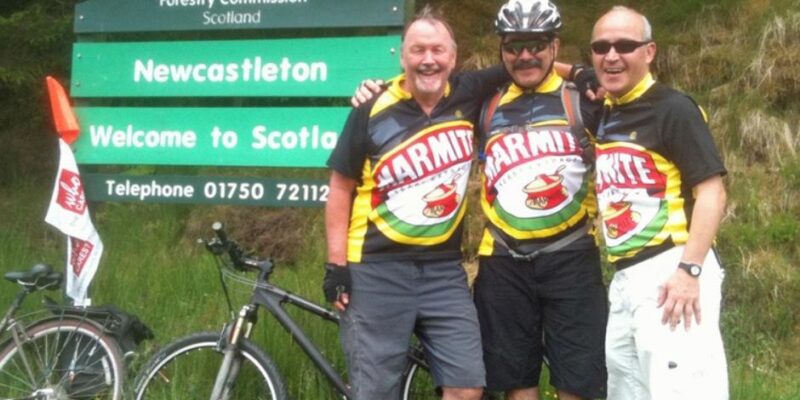 Andy, Eduardo and friend stand at the border between England and Scotland