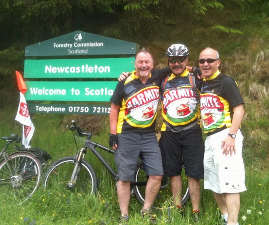 Andy, Eduardo and friend stand at the border between England and Scotland
