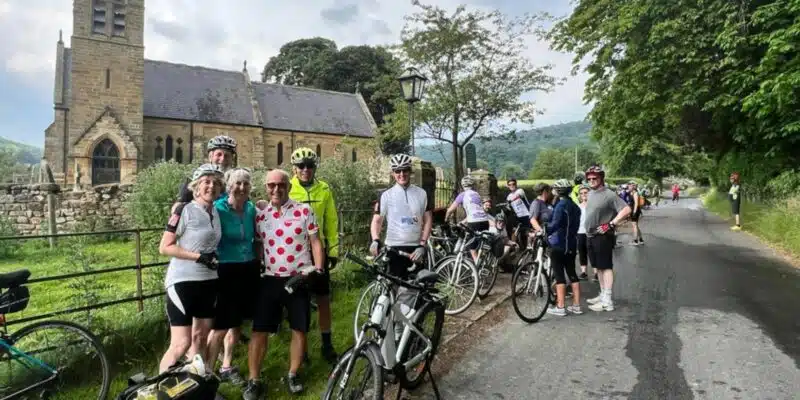 Group of cyclists standing in front of a church