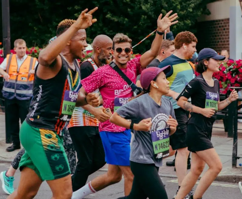Sahil running the Big Half 2023 and waving at the crowd