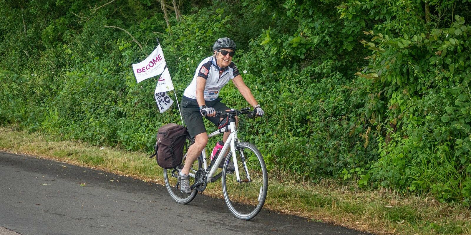 Gill cycling with Become flag on the back of the bike