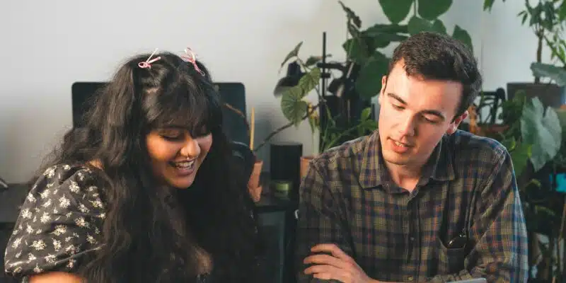 Young person and adult looking at a laptop