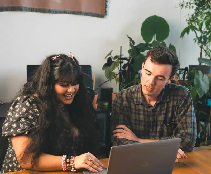 Young person and adult looking at a laptop