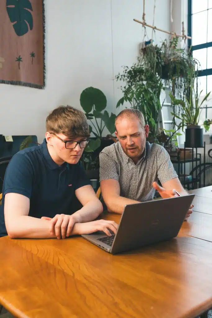 Two people looking at a laptop screen