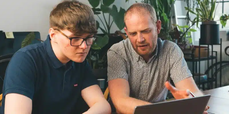 Two people looking at a laptop screen