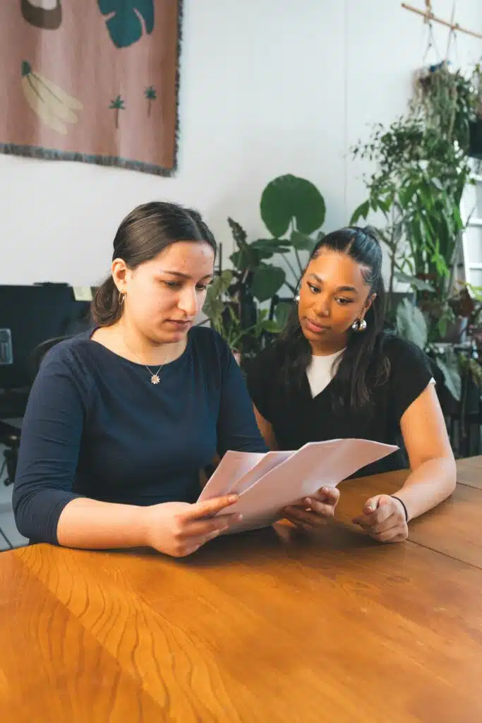 Two people at a desk looking at paper